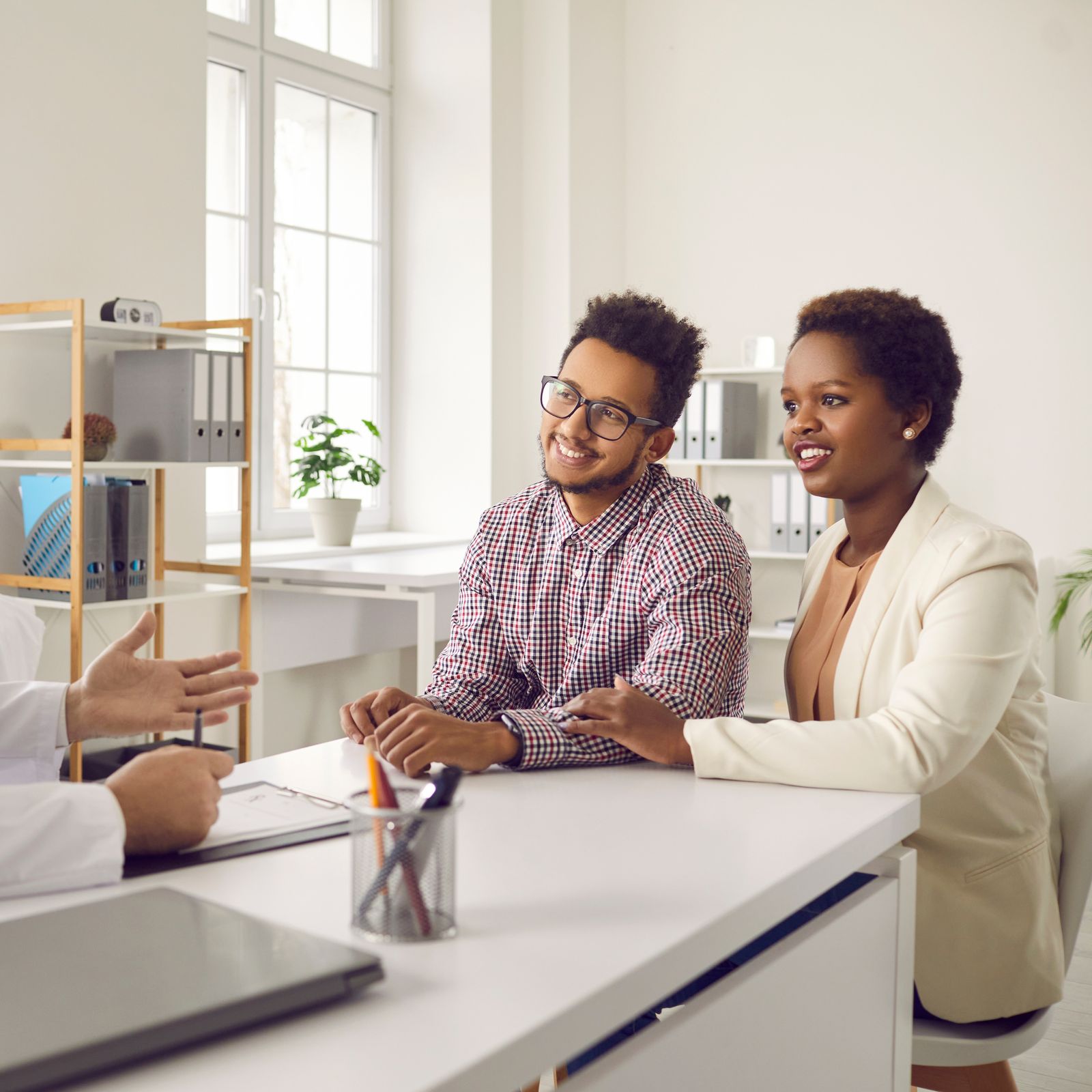 A doctor discussing fertility treatment with a couple at a consultation