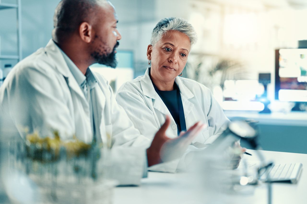 Two colleagues discussing results at a laboratory bench