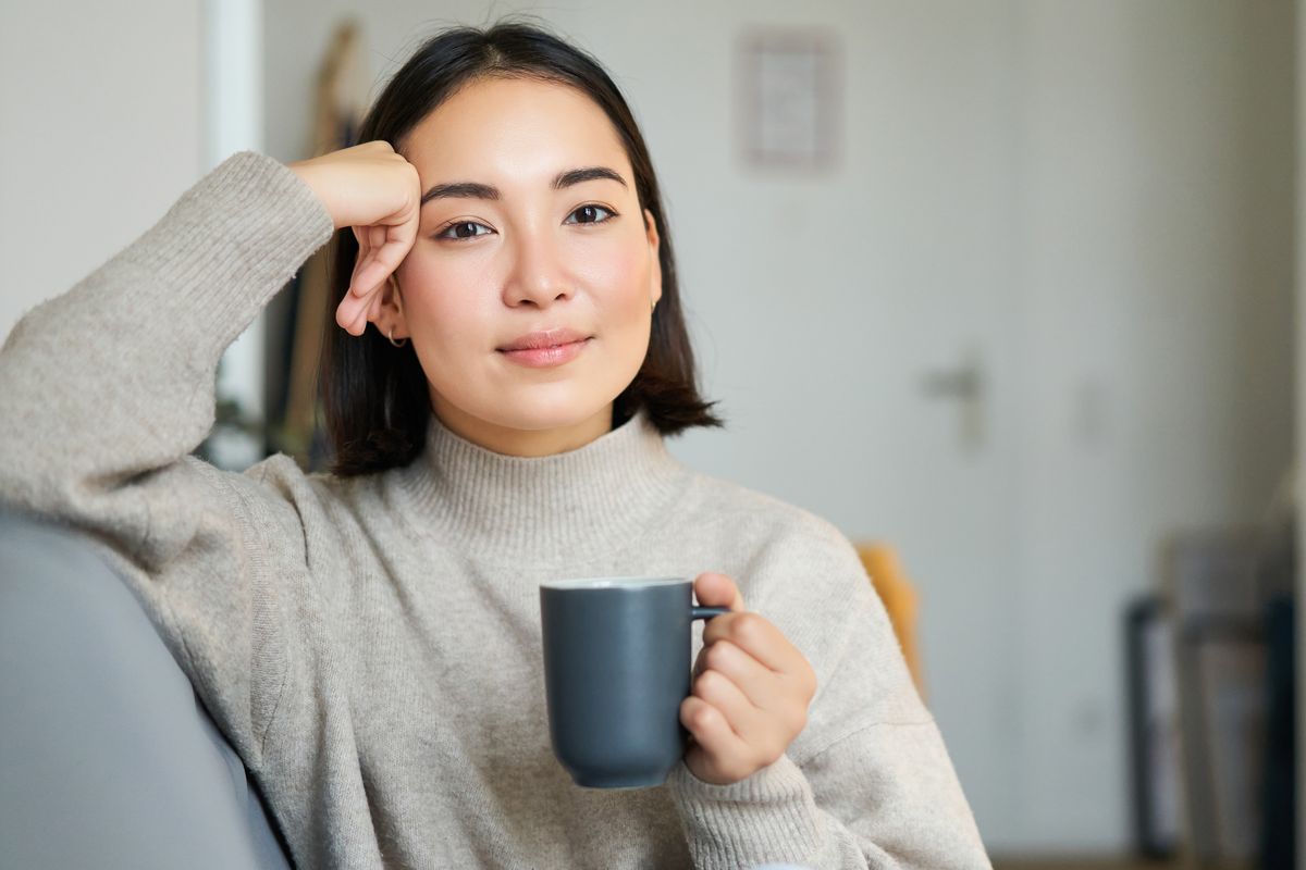 A woman relaxing on a sofa with a mug